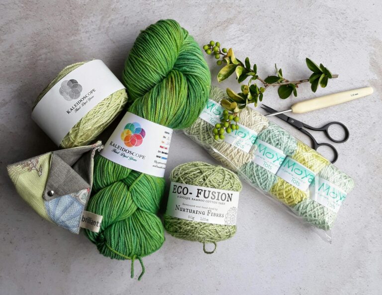 Assorted yarns and crochet tools arranged on a flat surface for a crafting session.